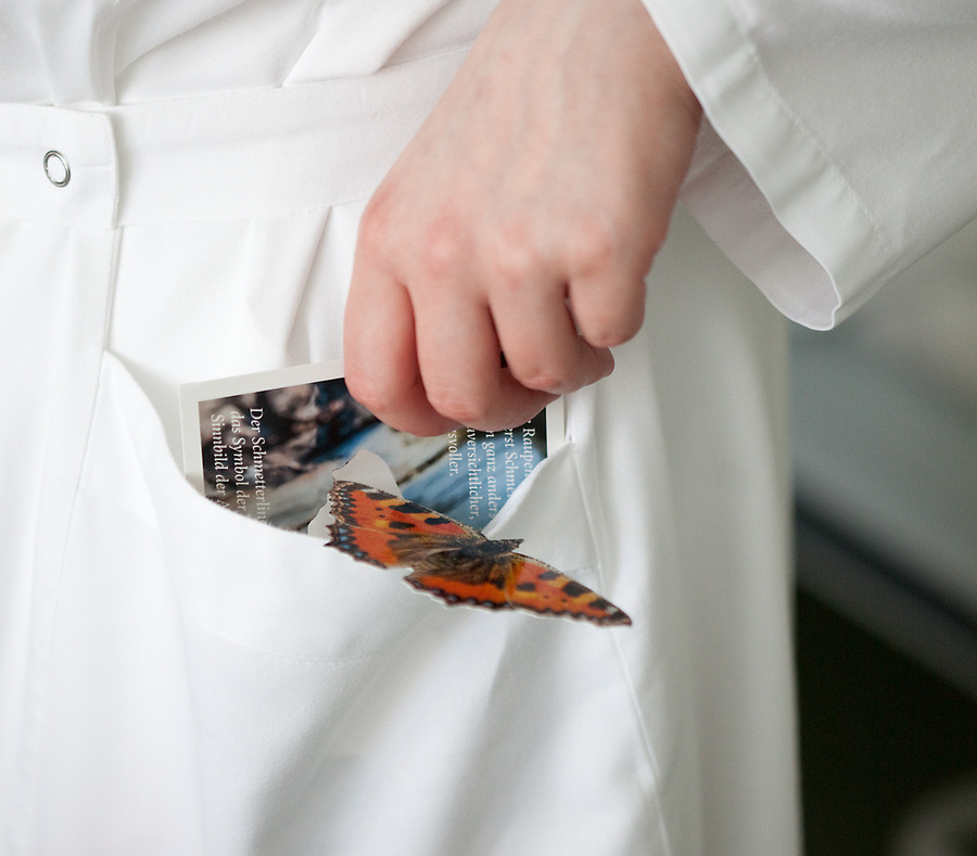Das Bild zeigt eine Ordensfrau mit einem Schmetterling am Habit