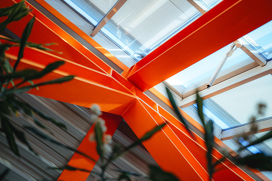 Das Schulgebäude der Ursulinen fällt besonders durch seine markanten, leuchtend orangefarbenen Stahlfachträger in Dreiecksform auf.