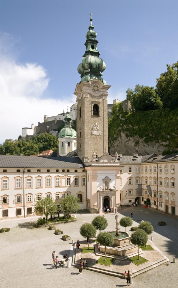 Erzabtei St. Peter, Stiftskirche / Verlag St. Peter, Mag. Reinhard Weidl Blick in den äußeren Stiftshof mit Kirchenfassade, Turm und Vierungskuppel sowie Brunnen; im Hintergrund die Festung Hohensalzburg
