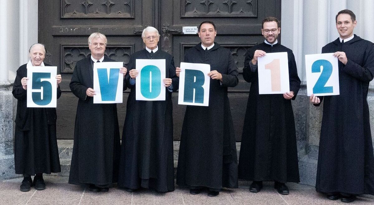 Das Bild zeigt Ordensmänner vom Stift Admont mit dem Schriftzug 5vor12