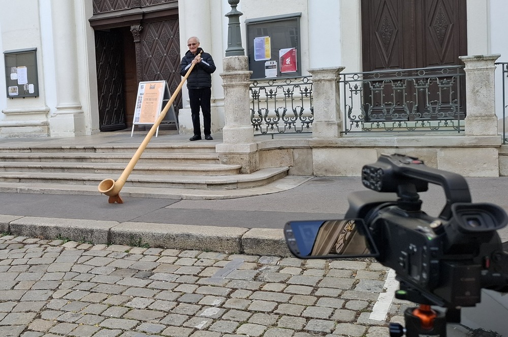 P. Werner Hebeisen mit dem Alphorn vor der Wiener Jesuitenkirche