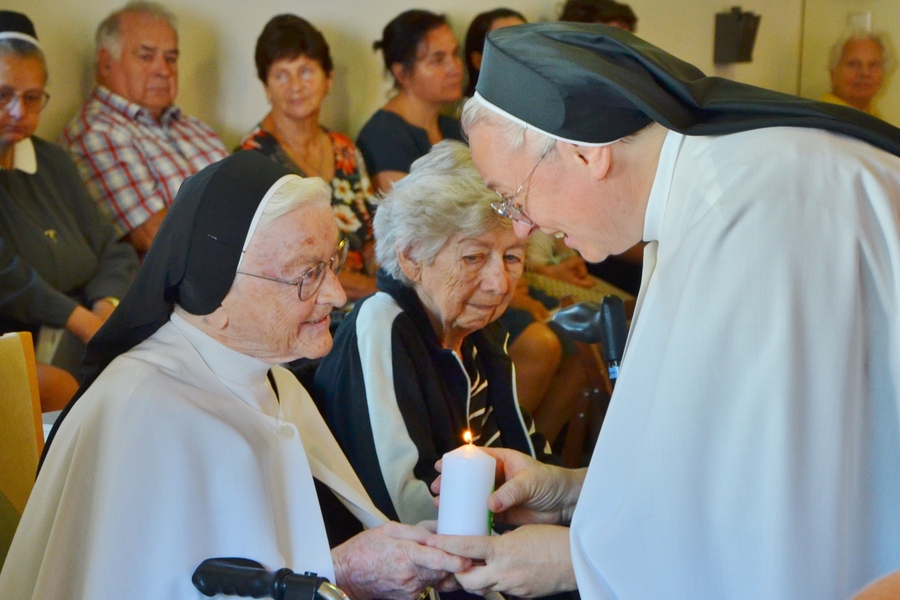 Generaloberin Sr. Margret Grill (r.) gab jeder Schwester des ehemaligen St. Teresa-Konvents das Licht der Osterkerze mit. Hier im Bild: Sr. Sabina Baumgartner.
