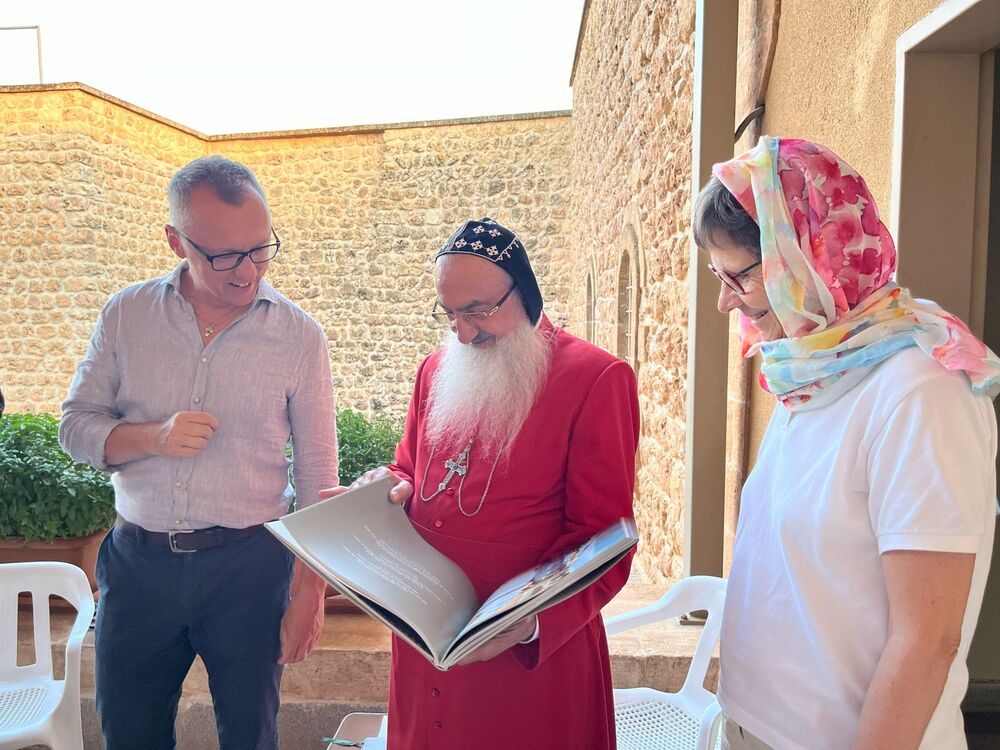 Peter Bohynik und Sr. Christine Rod überreichen Erzbischof Mor Thimotheos Samuel Aktas ein Gastgeschenk aus Österreich. 